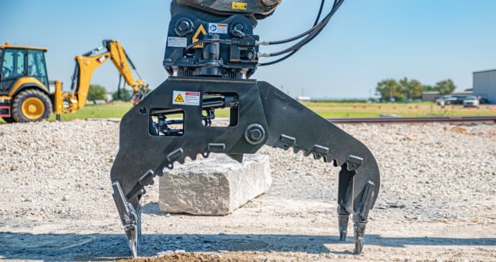 Close up picture of Dymax rotating stone grapple with quarry block in background