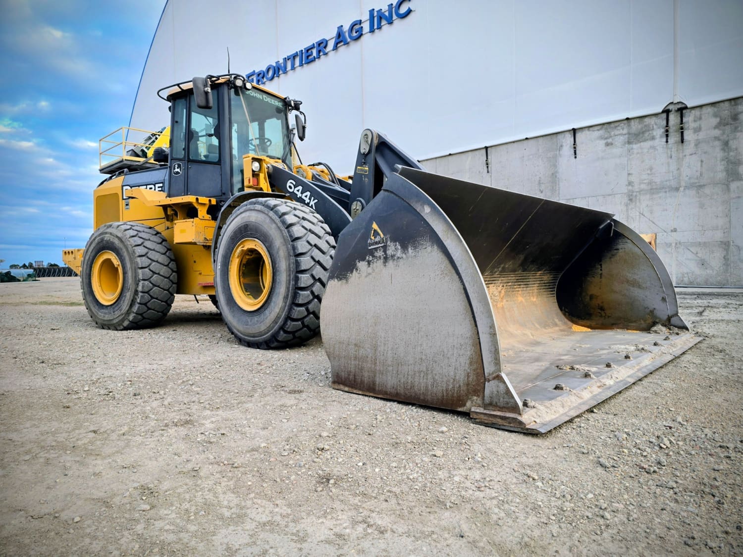 dymax-extra-wide-corn-bucket-john-deere-644k-frontier-ag.jpg A John Deere 644K loader equipped with a Dymax extra-wide corn bucket at Frontier Ag, used for efficient bulk corn loading.